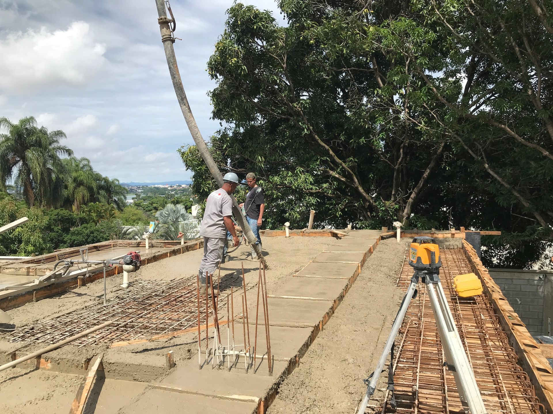 Um grupo de trabalhadores da construção civil está trabalhando em um piso de concreto.