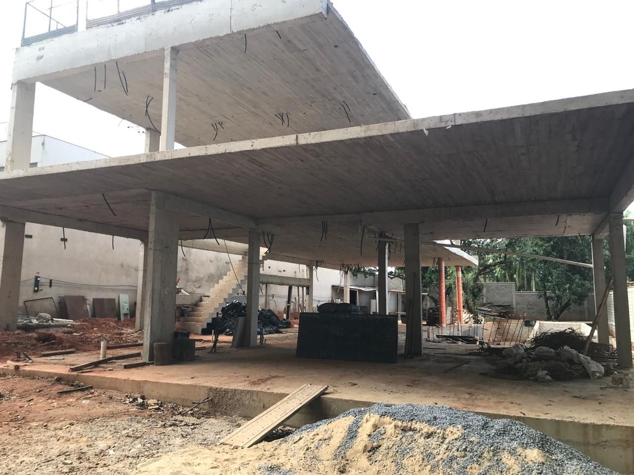 Um grande edifício em construção com muita sujeira no primeiro plano.