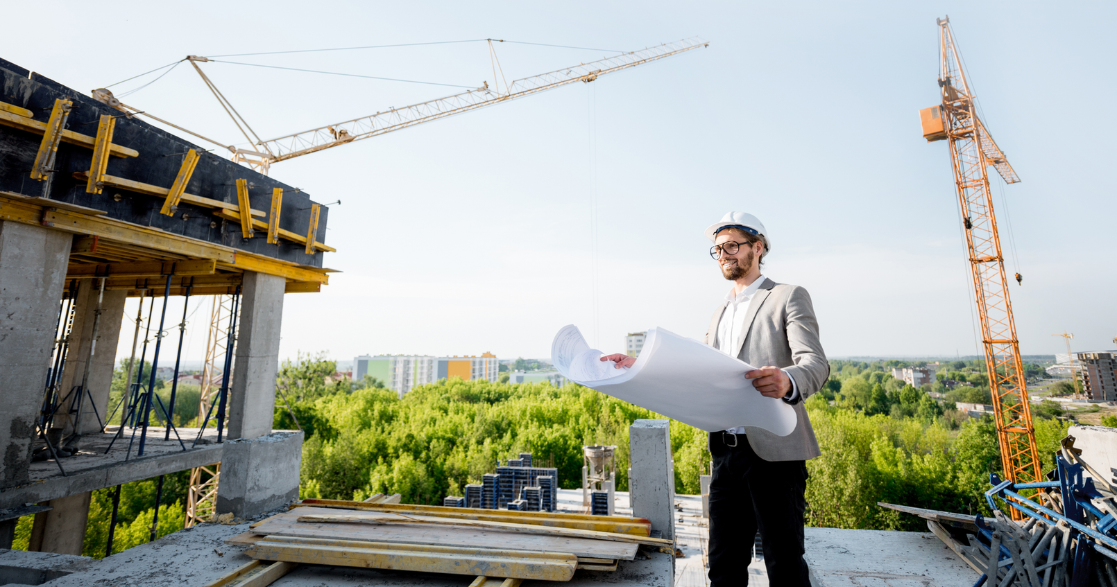 Um homem está olhando para uma planta em um canteiro de obras.