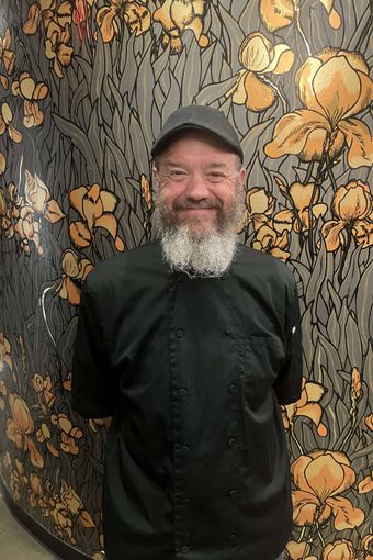 Silhouette of a person with curly hair, glasses, and a collared shirt, facing to the side.