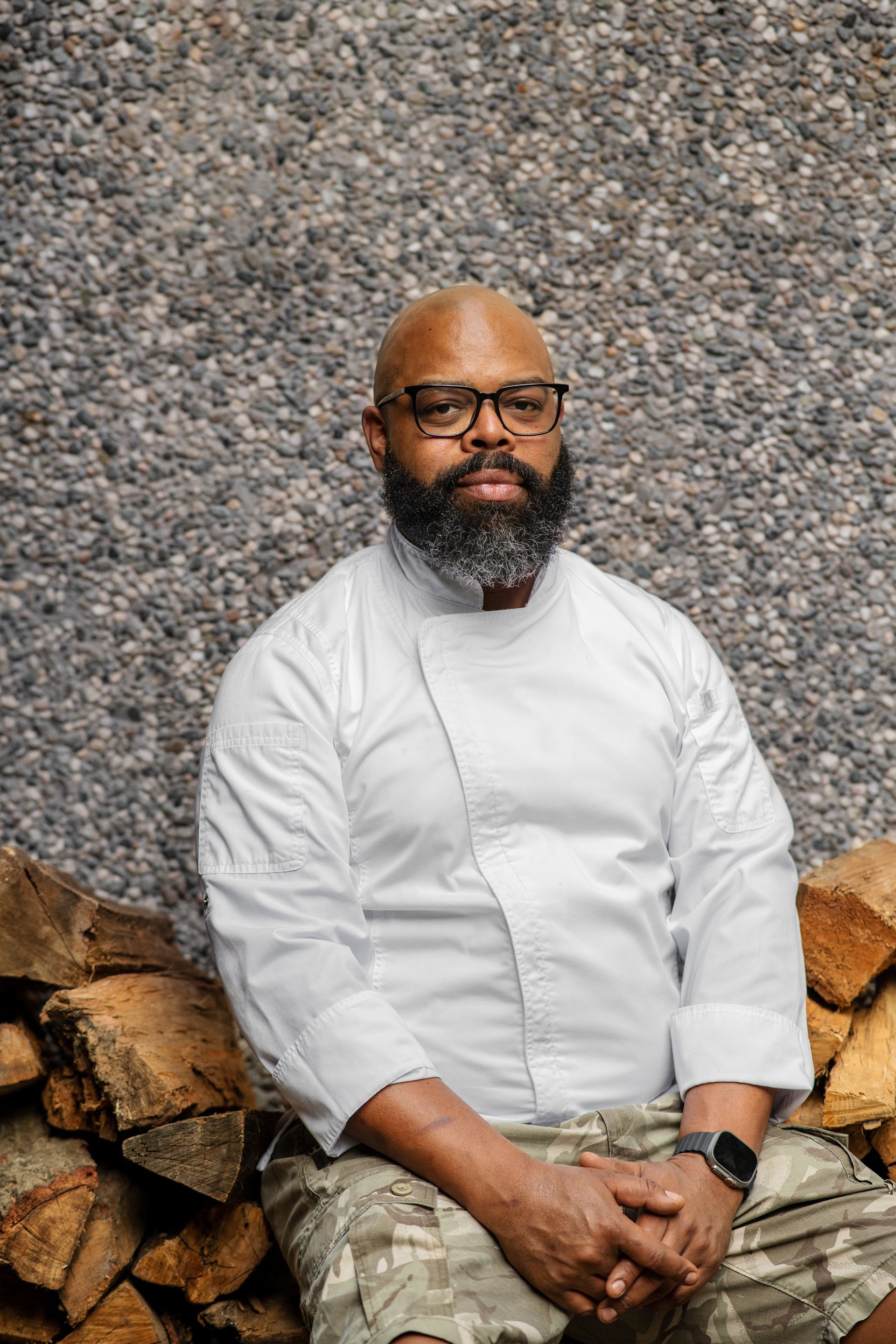 Silhouette of a person with curly hair, glasses, and a collared shirt, facing to the side.