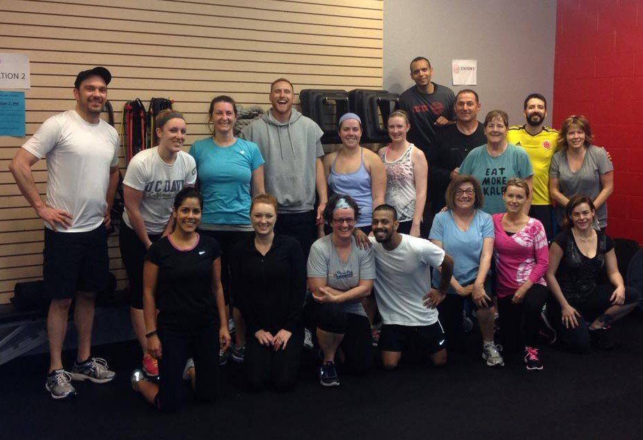 A group of people are posing for a picture in a gym.
