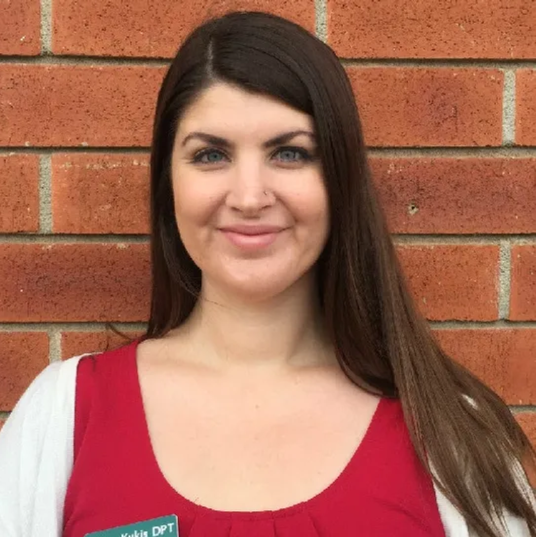 A woman in a red shirt with a name tag that says dpt