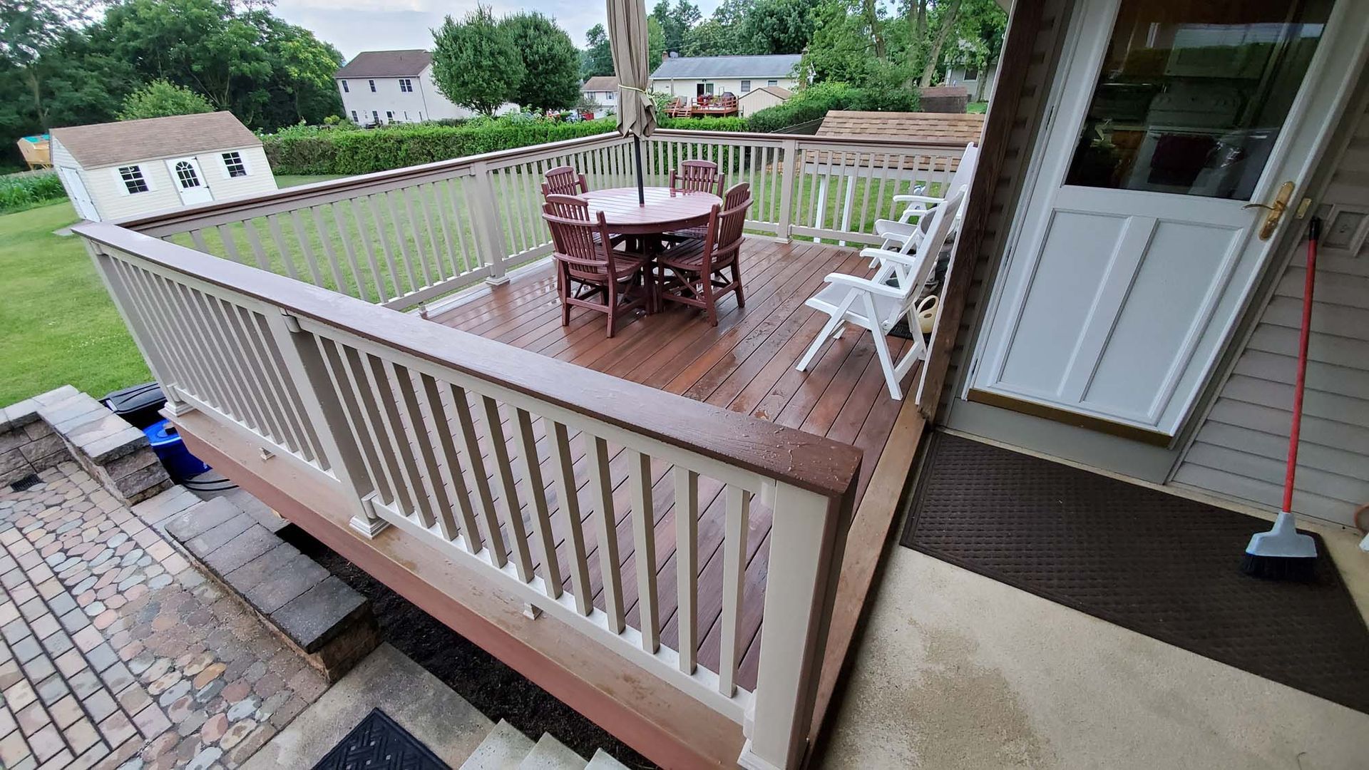 There is a deck with a table and chairs on it.