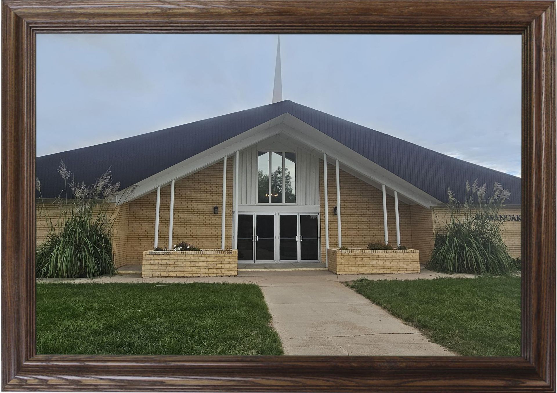 The front door of a house with a porch and plants in front of it.