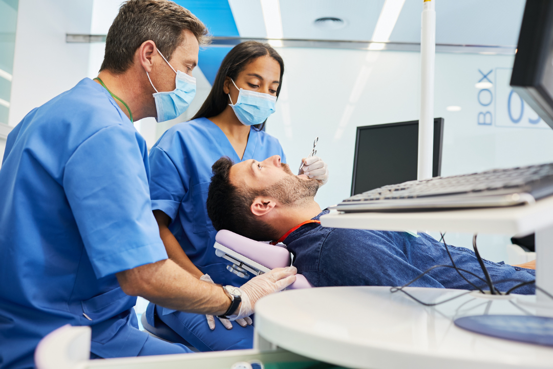 A woman is smiling while sitting in a dental chair.