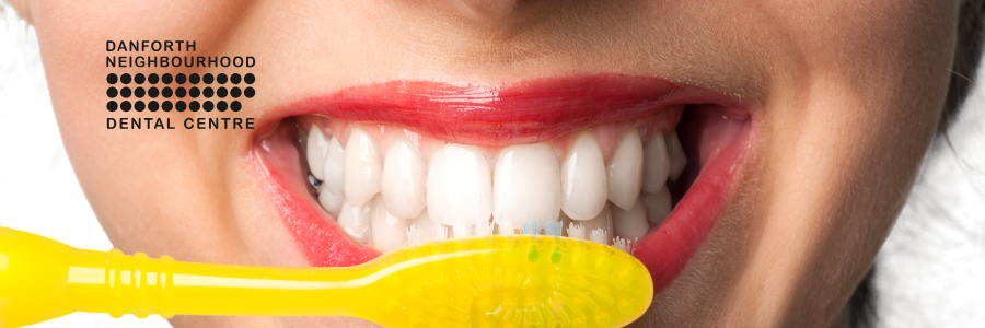 A woman is smiling while sitting in a dental chair.