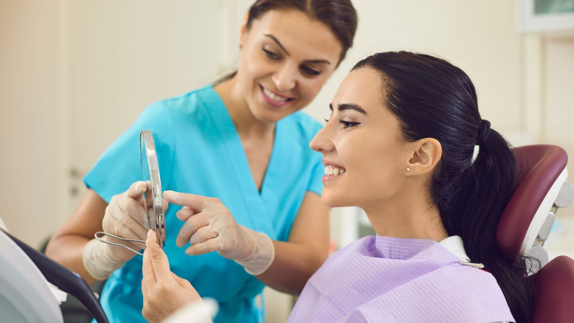 Dentist showing a clear dental aligner to a smiling patient in a dental chair