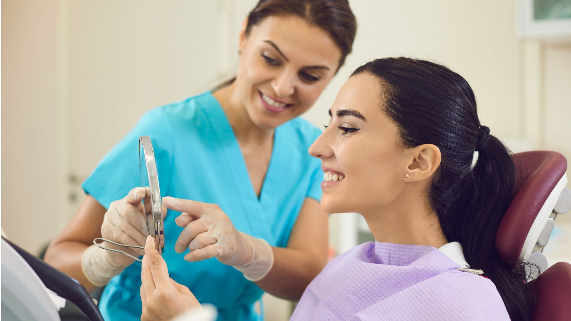 Dentist showing a patient a dental tool during a checkup in a clinic