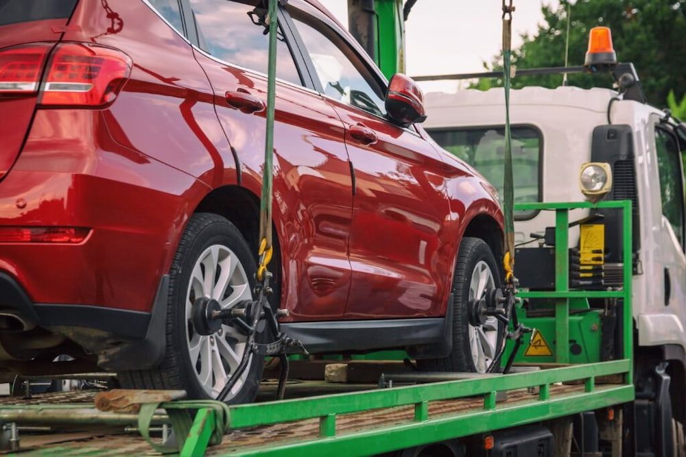 Red Car Being Towed on a Flatbed Tow Truck — Central Scrap Metal in Willawong, QLD