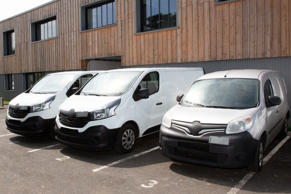 Three White Vans Parked in Front of a Wooden Building — Central Scrap Metal in Willawong, QLD