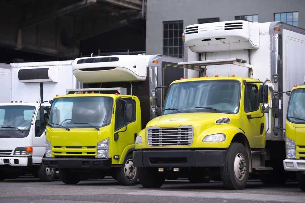 Yellow and White Refrigerated Trucks Parked in an Urban Setting — Central Scrap Metal in Redcliffe, QLD