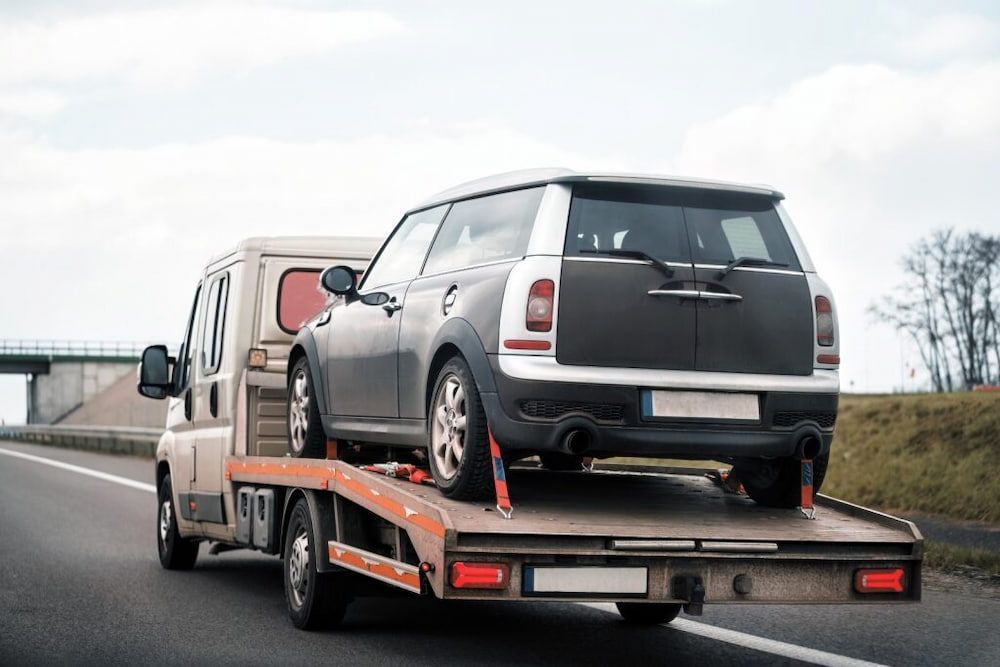 Mini Cooper Being Towed on a Flatbed Tow Truck on a Highway — Central Scrap Metal in Ipswich, QLD