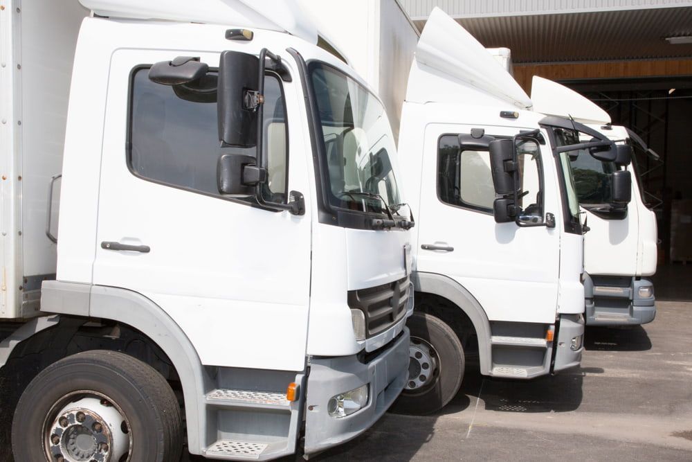 Three White Delivery Trucks Parked in a Row — Central Scrap Metal in Sunnybank, QLD