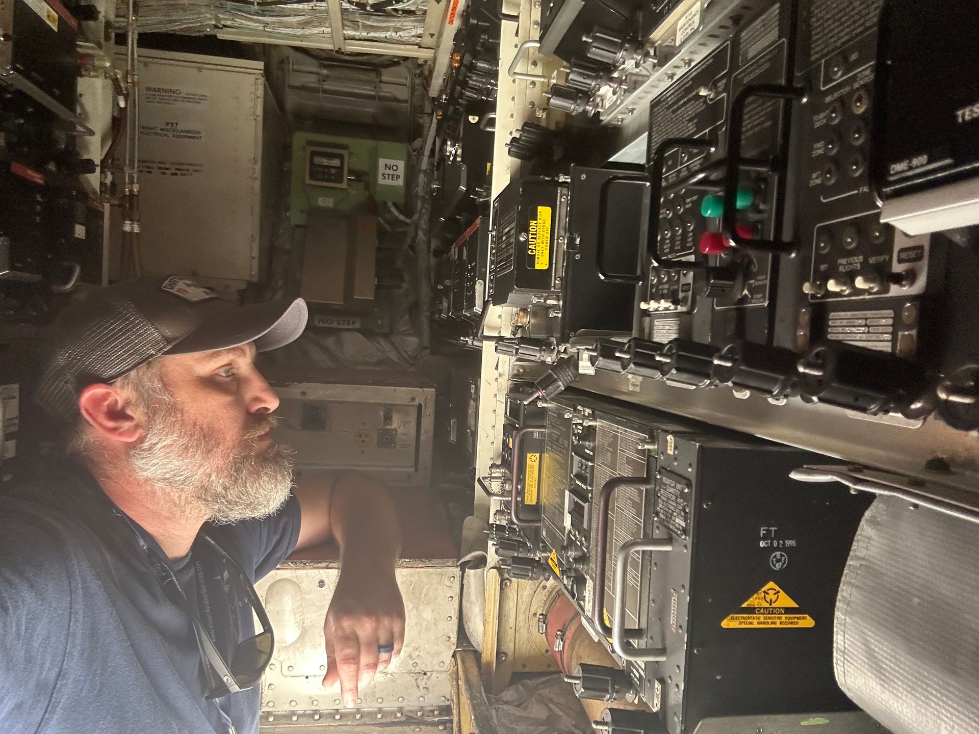 A man standing in a room with a yellow warning sign
