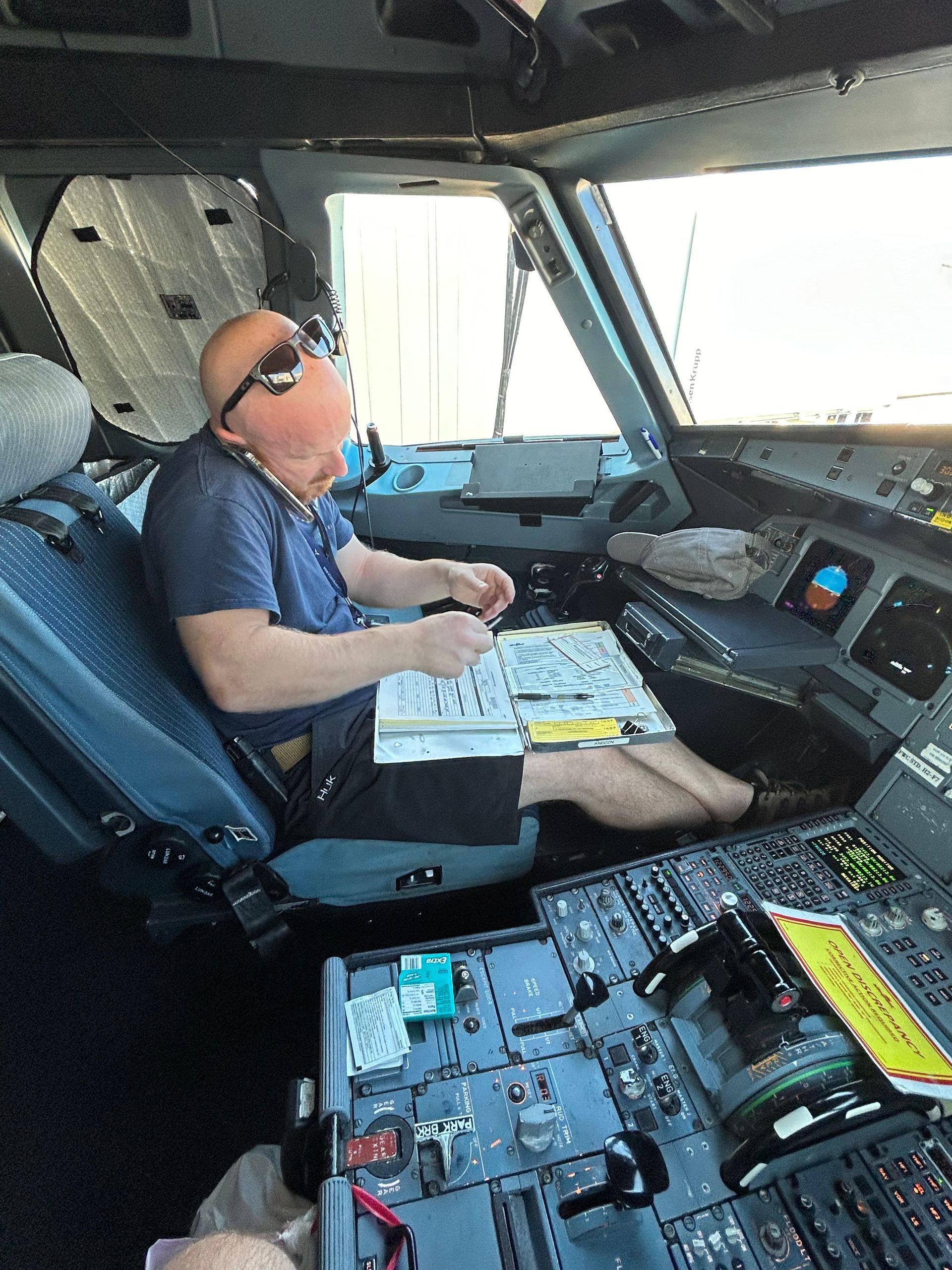 A man is sitting in the cockpit of an airplane