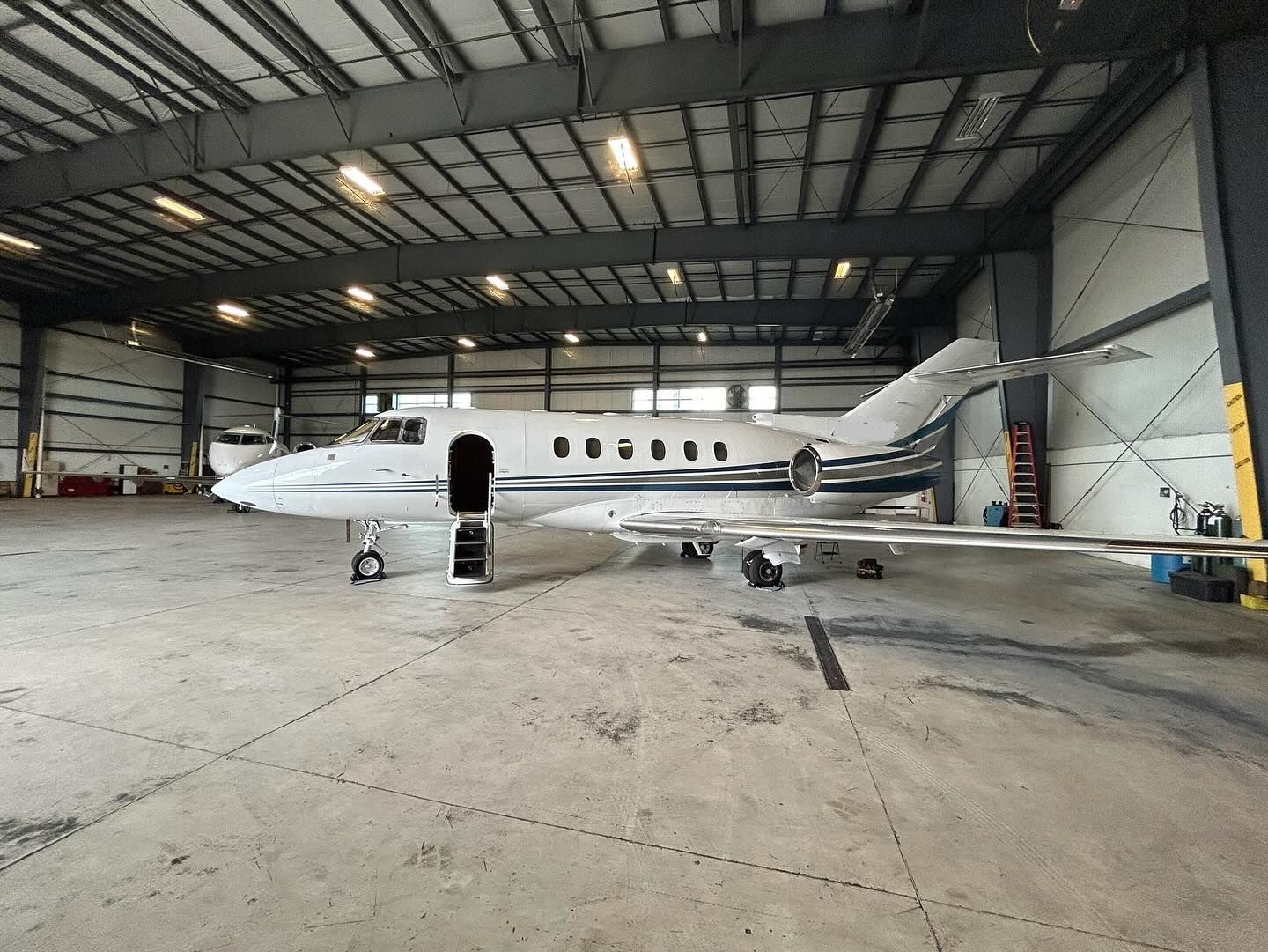 A small private jet is parked in a hangar.