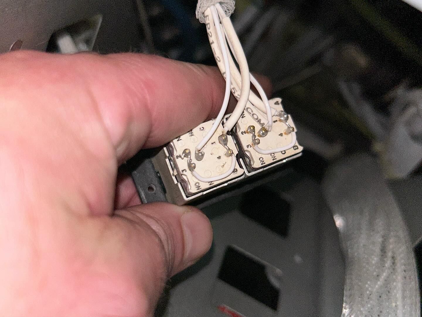 A person is holding a piece of electrical equipment in their hand.