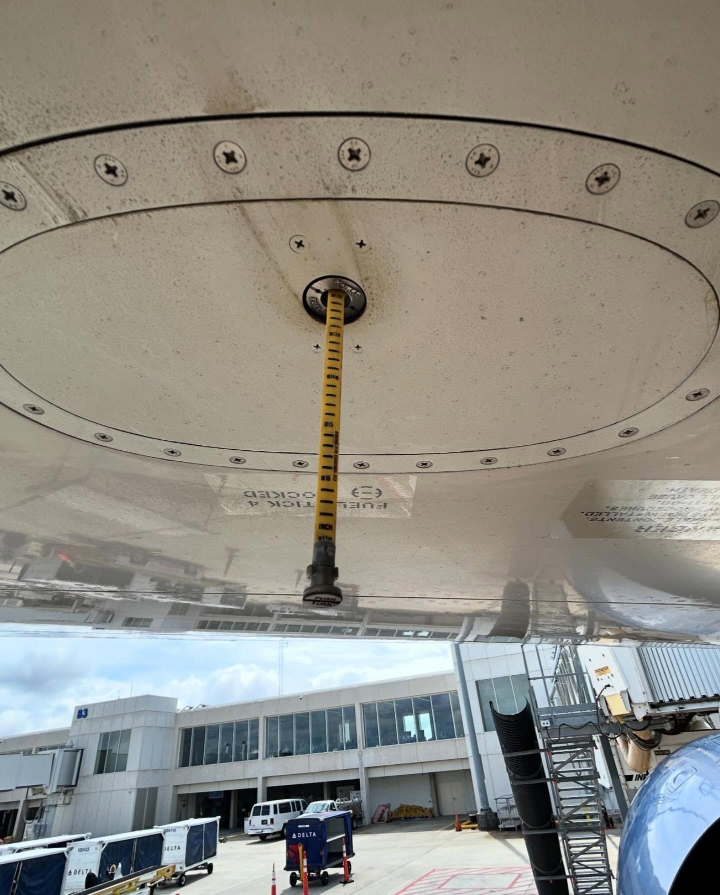 A yellow tape measure is hanging from the ceiling of an airplane