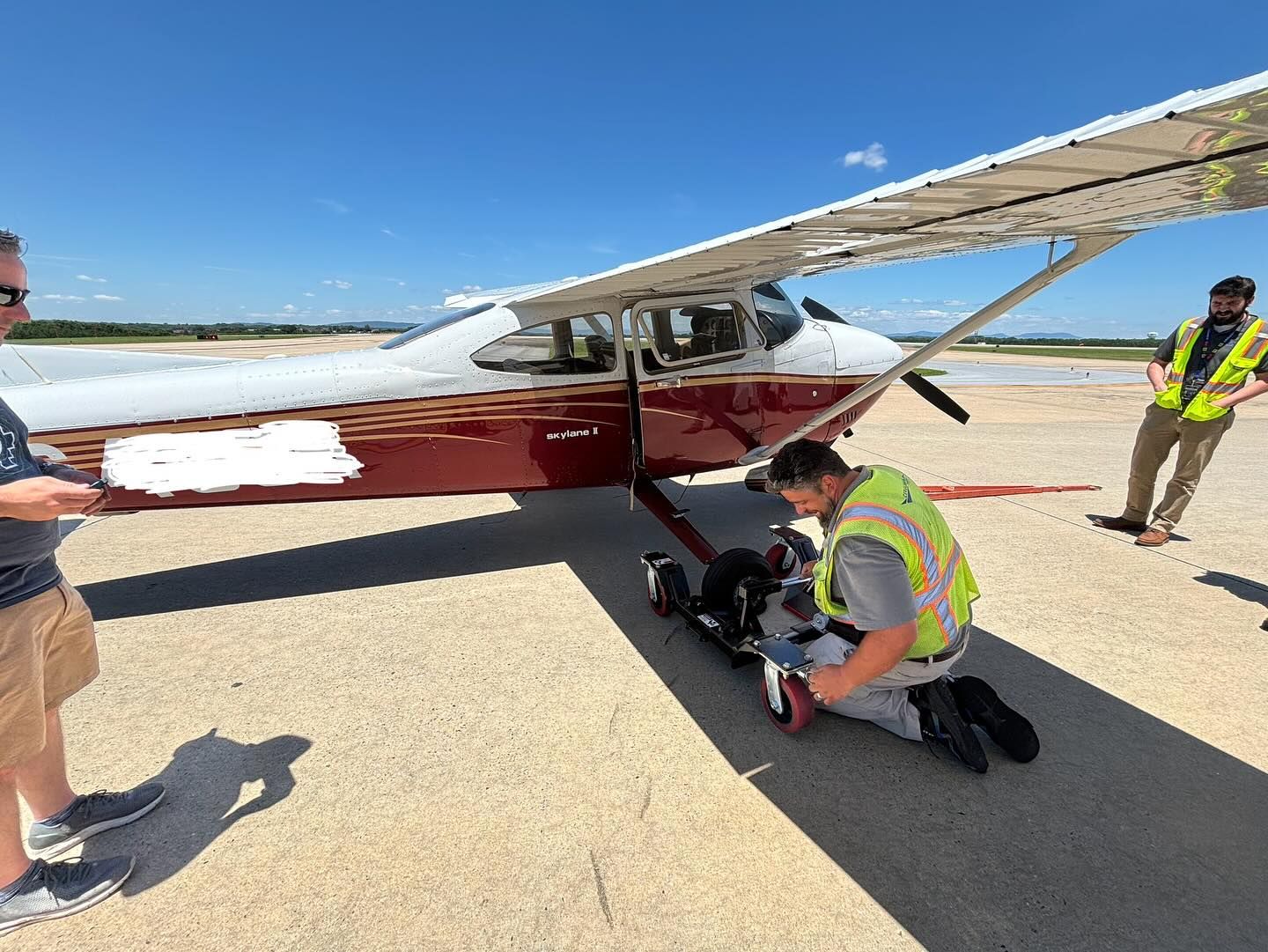 Two men are working on a small plane on a runway.