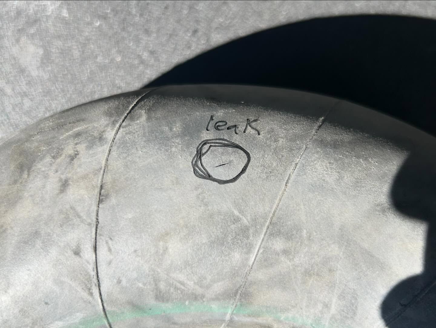 A close up of a tire with a leak written on it.