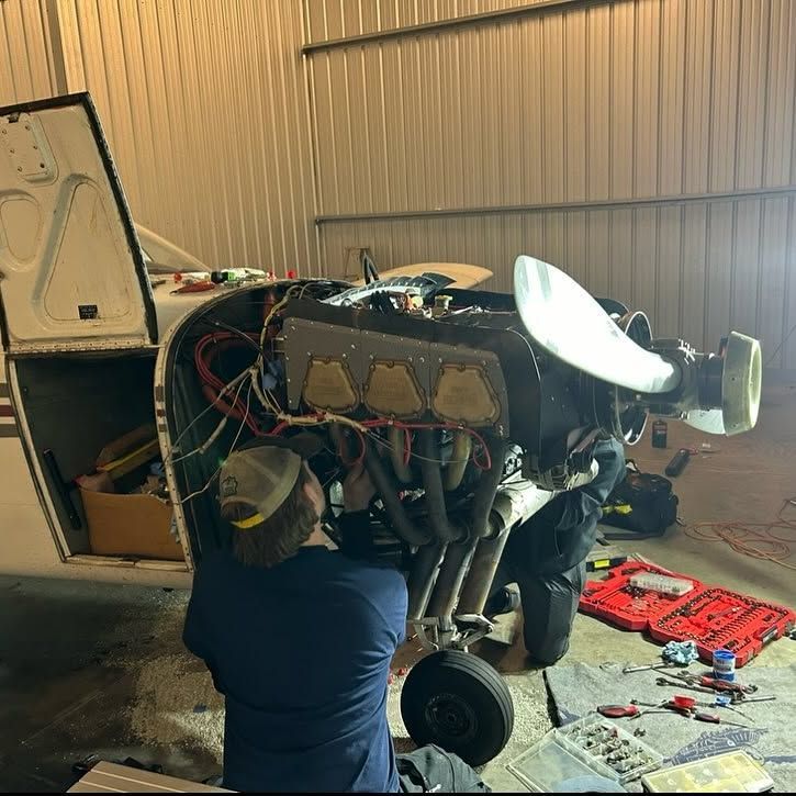 A man is working on the engine of an airplane