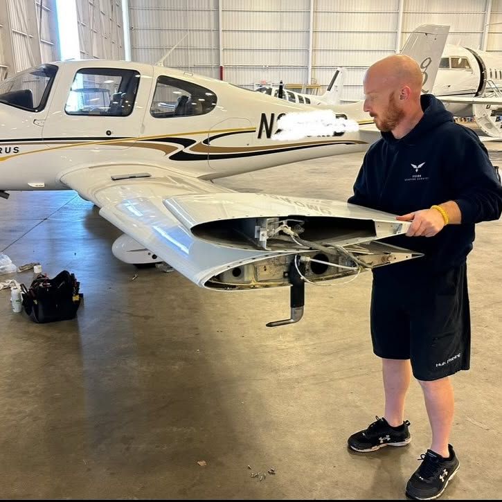 A man is standing in front of a plane with the letters n on it