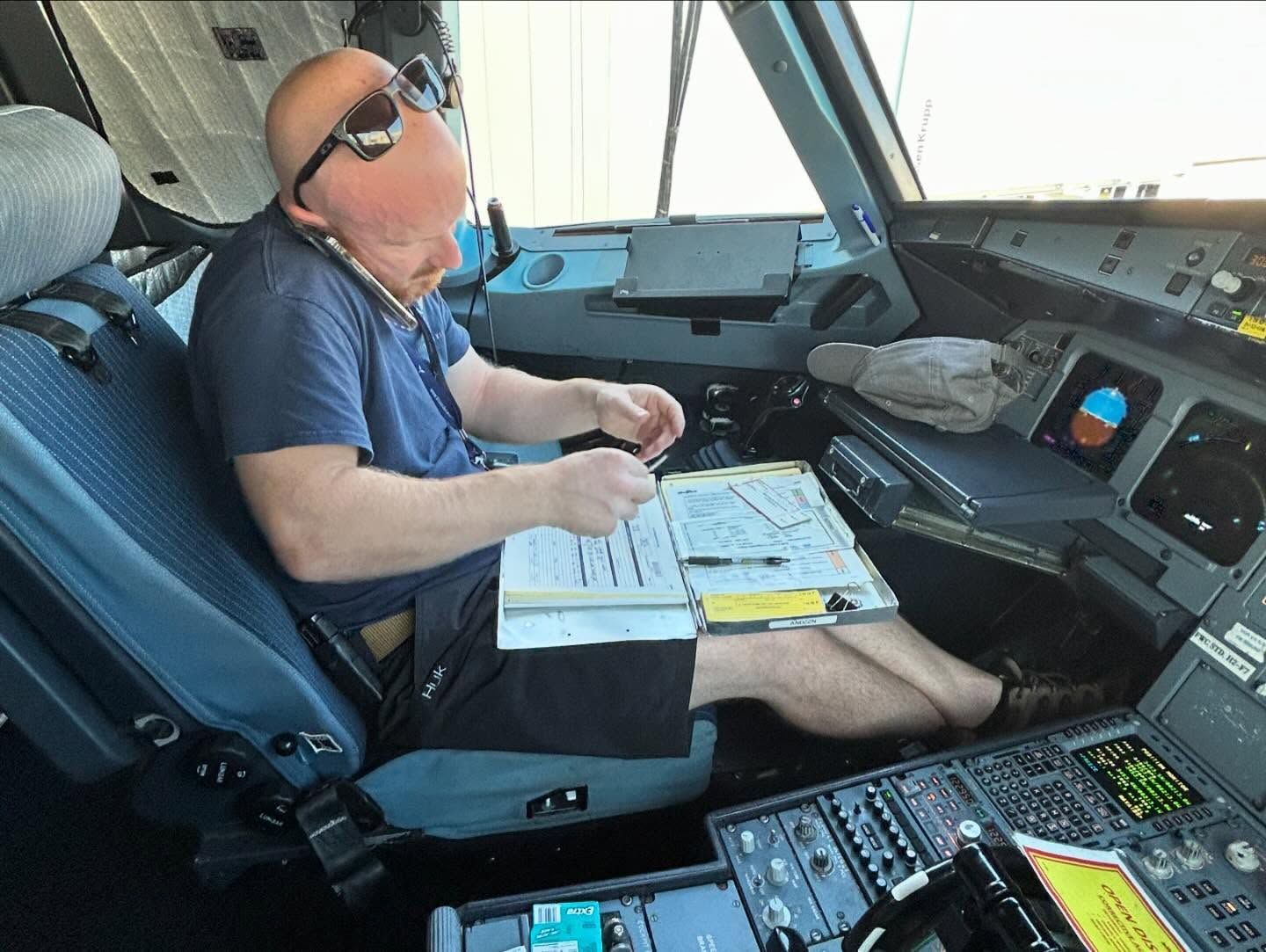 A man is sitting in the cockpit of an airplane