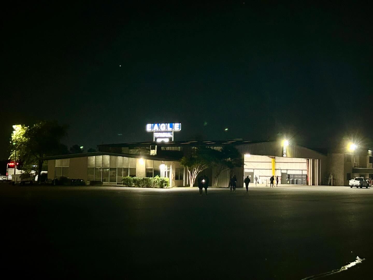 A large building with the word eagle on top of it at night