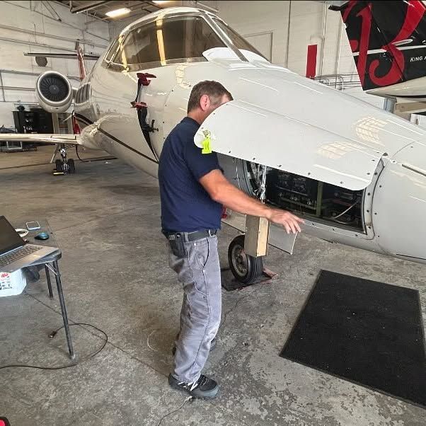 A man is working on an airplane in a hangar