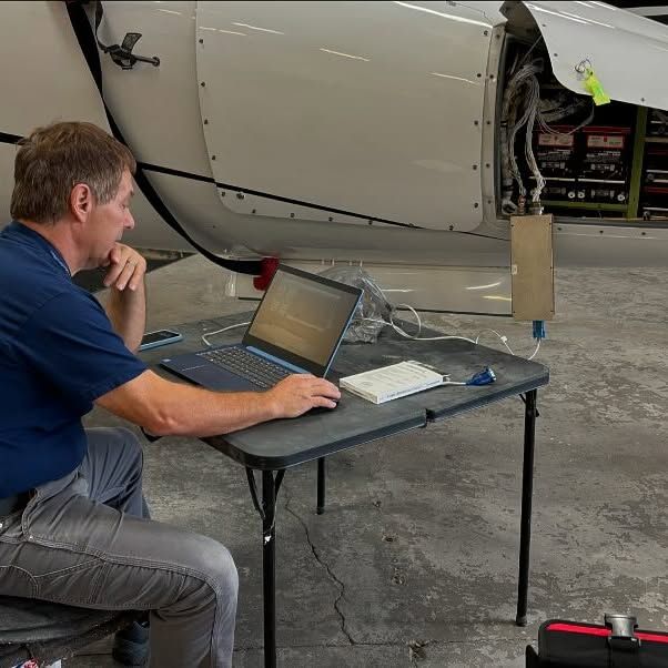A man is sitting at a table with a laptop on it