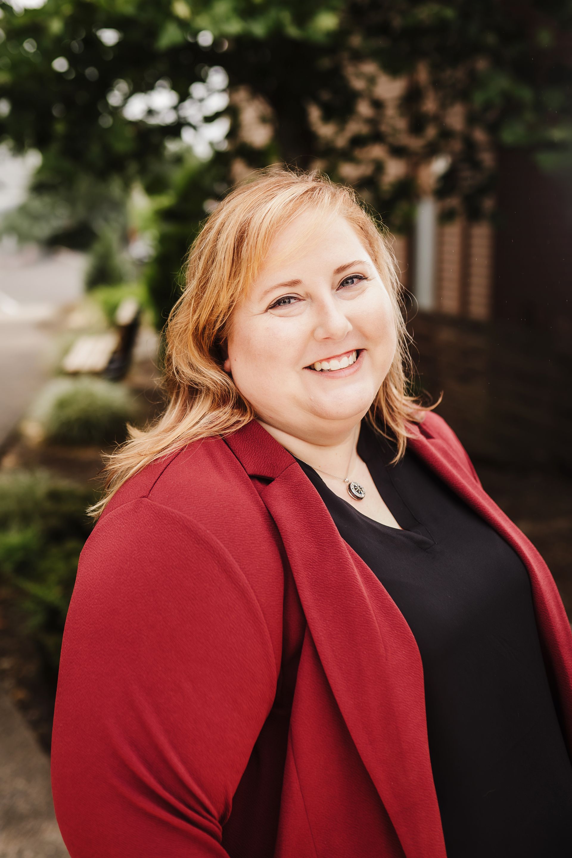 A woman with blonde hair and blue eyes is smiling for the camera.