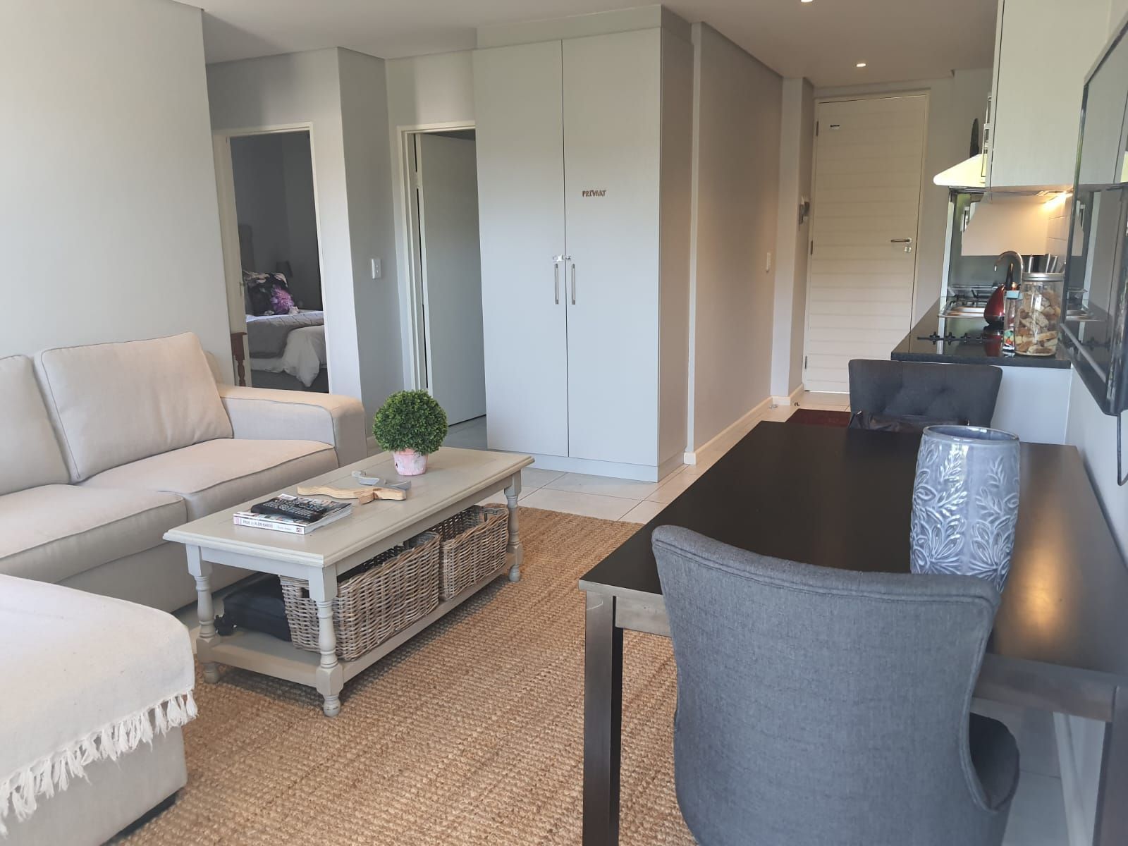 A living room with a couch , table and chairs