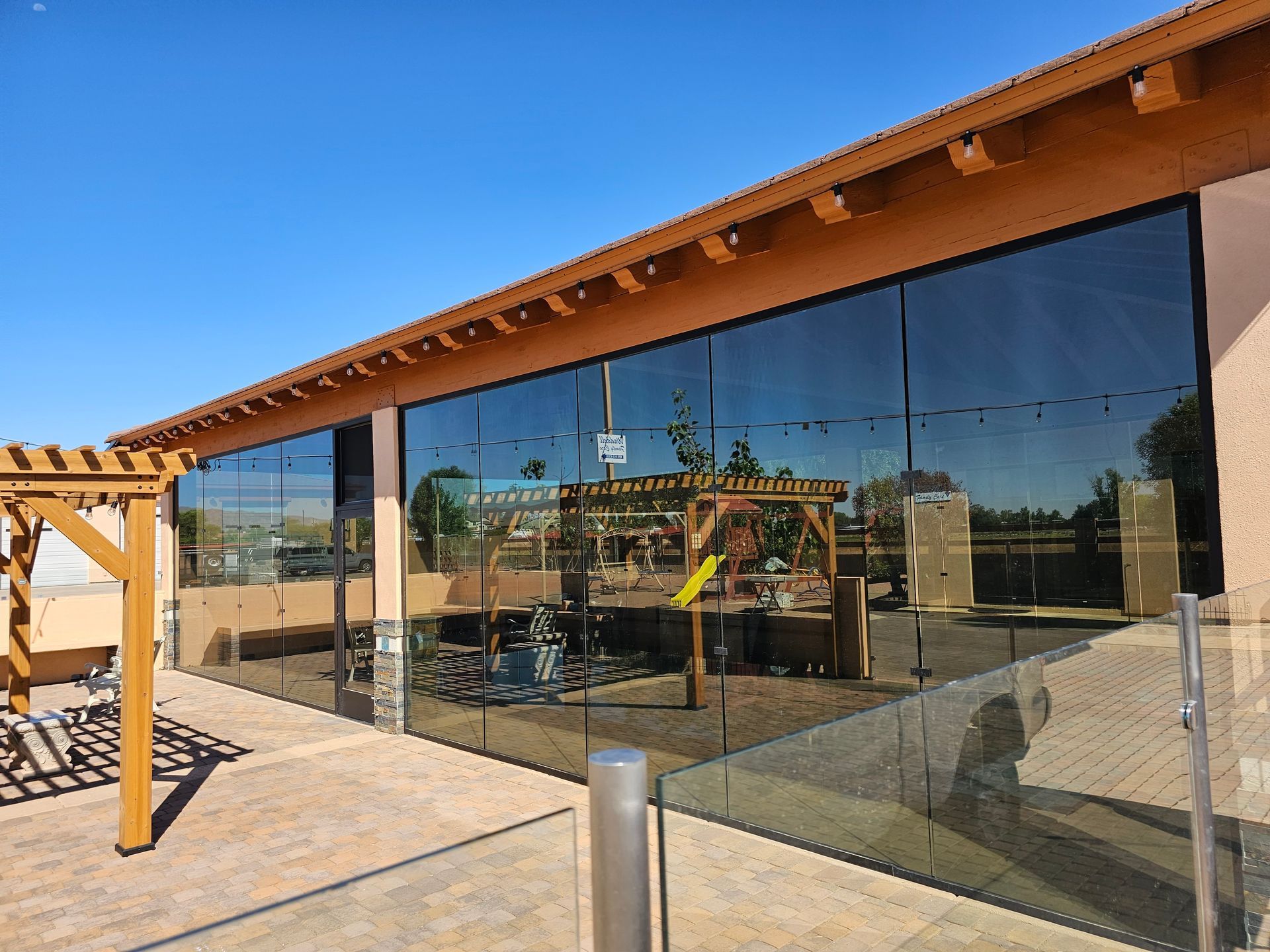 A large glass building with a playground in the background