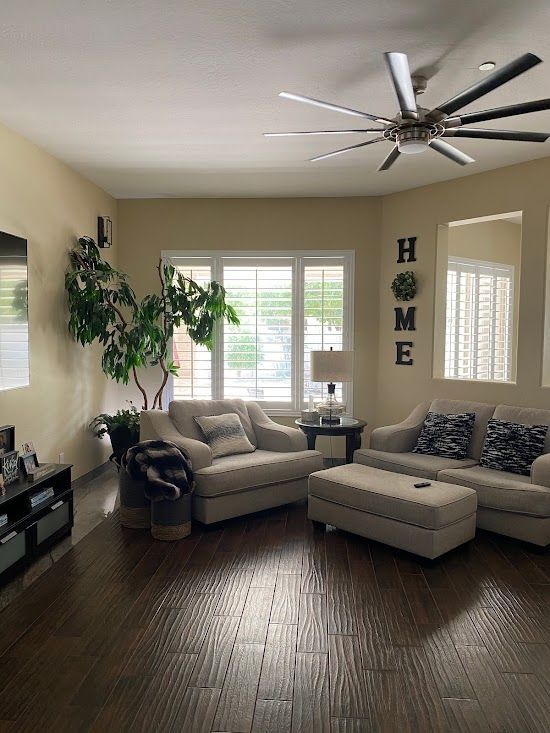 A living room filled with furniture and a ceiling fan.
