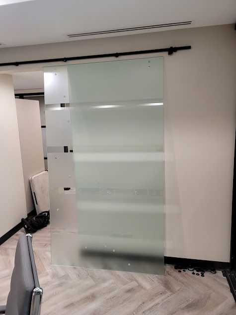 A sliding glass door in a room with a chair.