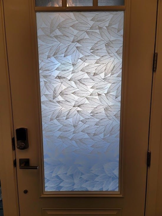 A door with a stained glass window with leaves on it.