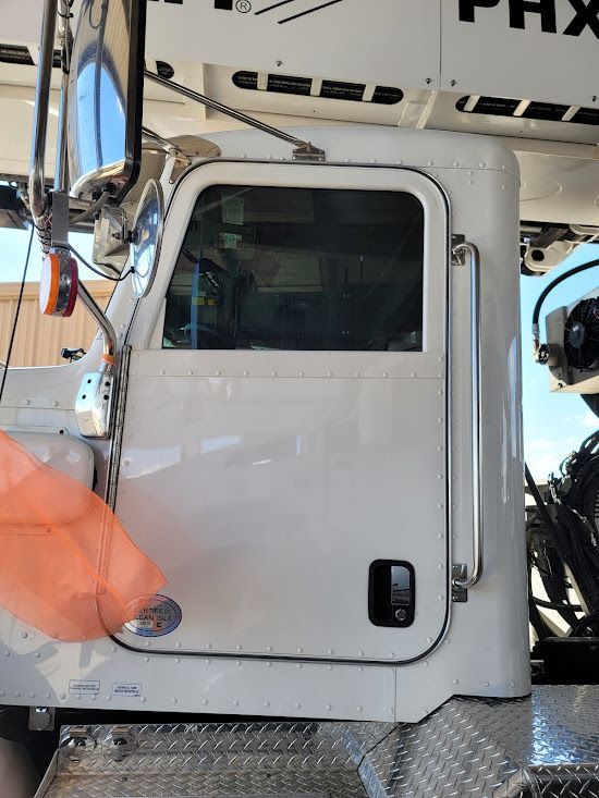 A white semi truck is parked in a parking lot.