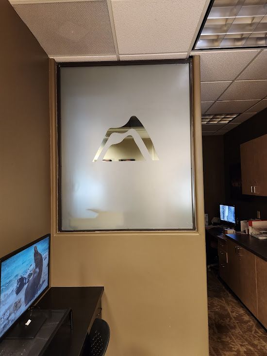 A room with a computer and a window with a logo on it