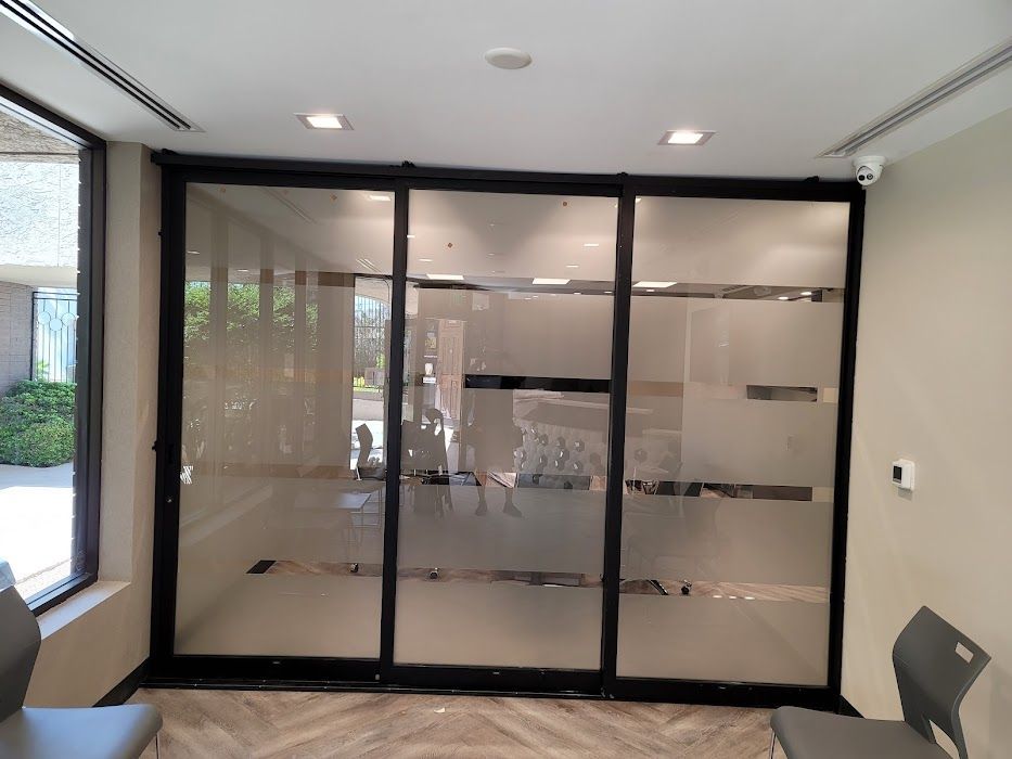 A waiting room with sliding glass doors and chairs.