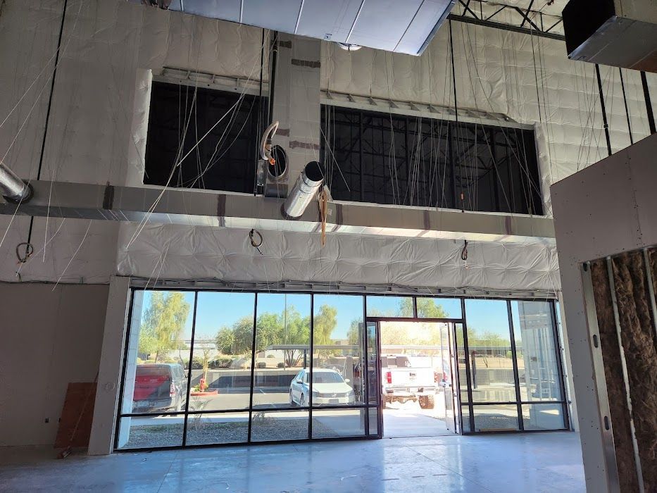A man is working on the ceiling of an empty building.