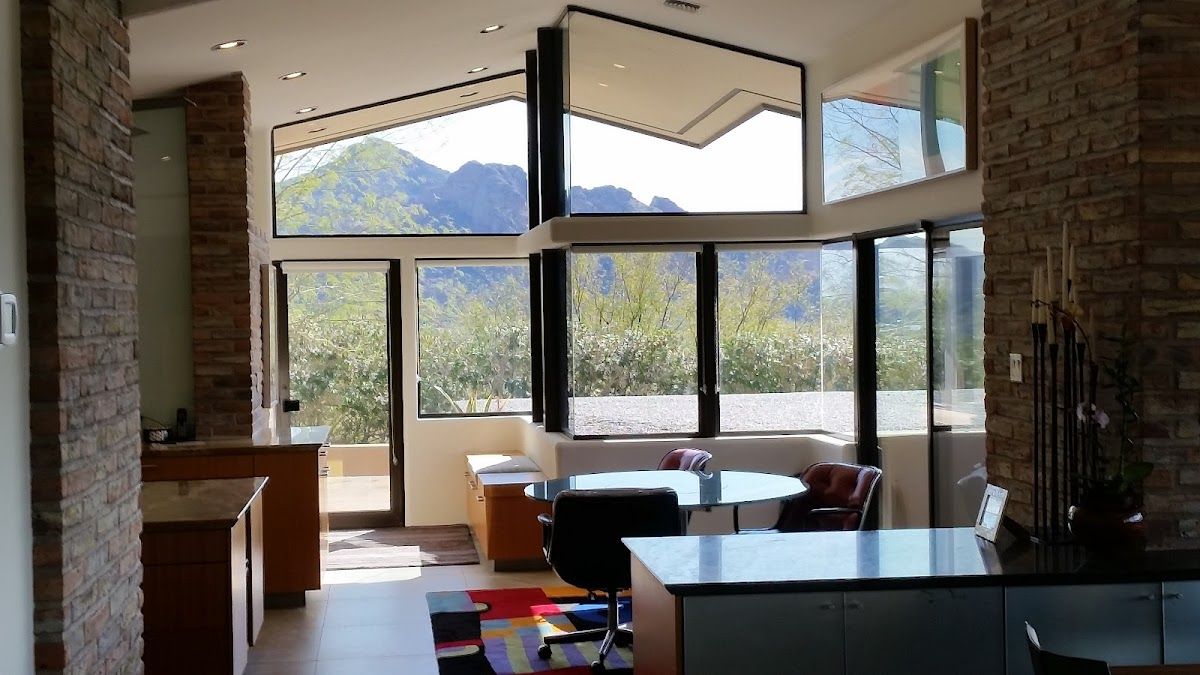 A living room with a lot of windows and a mountain in the background