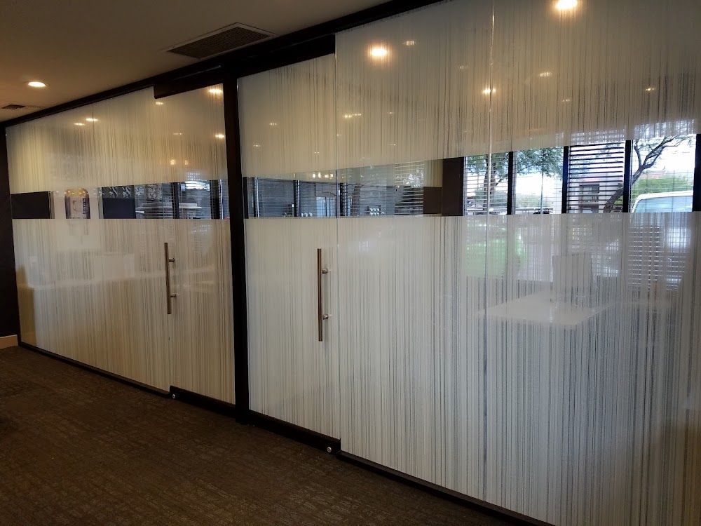 A hallway with sliding glass doors and a striped glass wall.