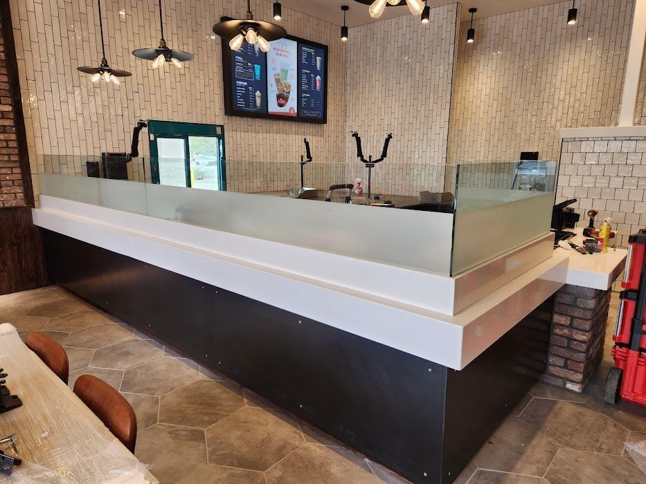 A restaurant with a long counter and a refrigerator.