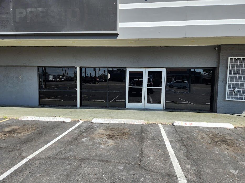 A building with a lot of windows and a parking lot in front of it.