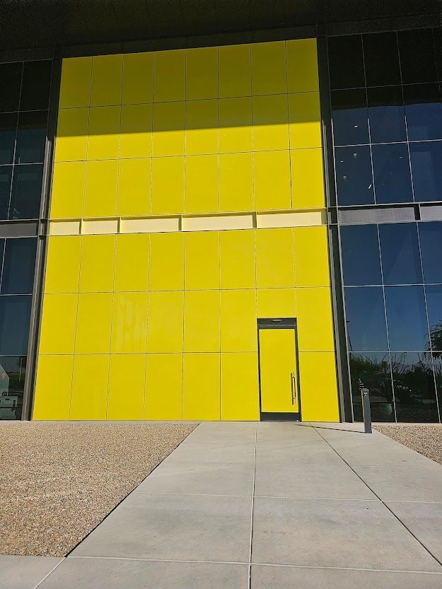 A large building with a yellow facade and a door