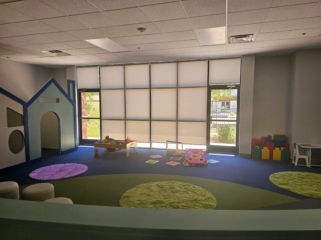 A large room with a lot of windows and toys in it.