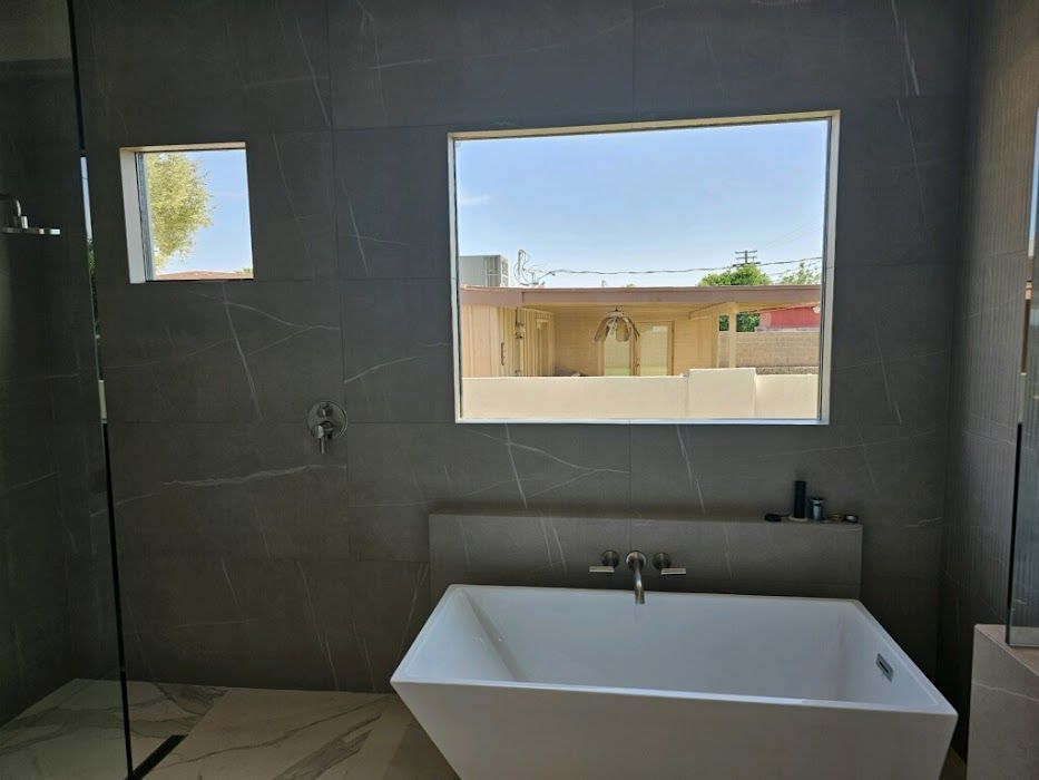 A bathroom with a bathtub and a window