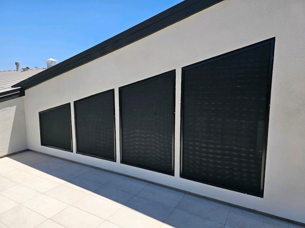 A row of black shutters on the side of a building.