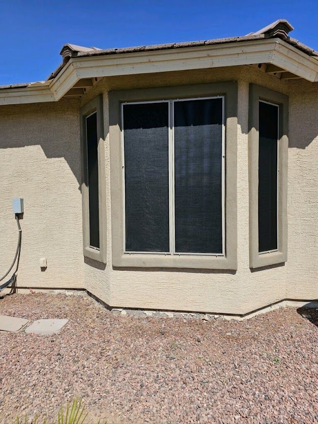 A house with a large bay window with a black curtain on it